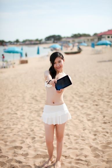 Hotgirl diện bikini nóng bỏng dạo biển cùng tablet