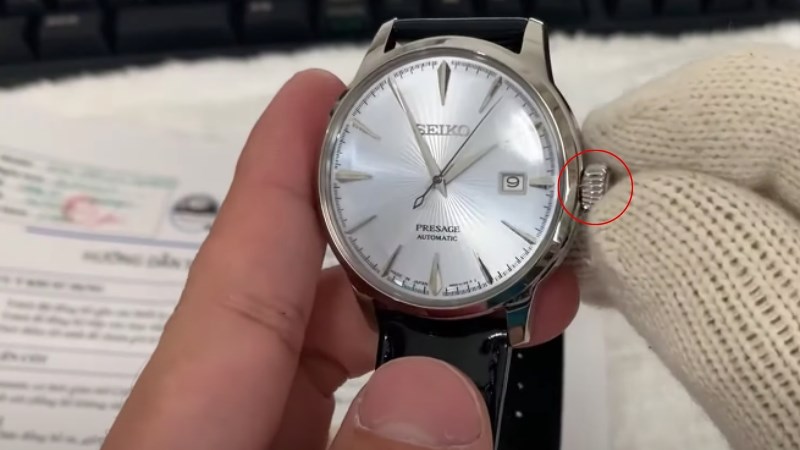 Lên dây cót cho chiếc đồng hồ bằng cách vặn núm đến khi căng đầy Lên dây cót cho chiếc đồng hồ bằng cách vặn núm đến khi căng đầy