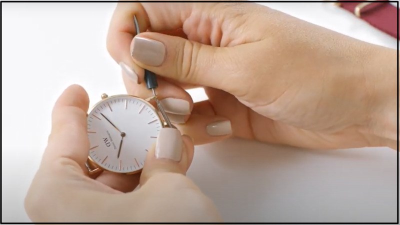 Dùng công cụ tháo chốt ở 2 bên đồng hồ Dùng công cụ tháo chốt ở 2 bên đồng hồ