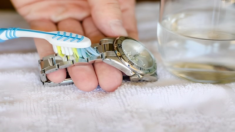 Dùng bàn chải để làm sạch các kẽ nhỏ trên đồng hồ Dùng bàn chải để làm sạch các kẽ nhỏ trên đồng hồ