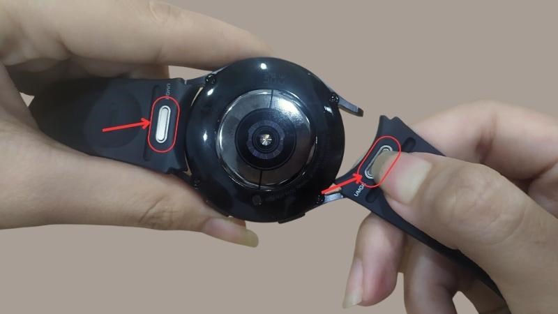 Nhấn nút và kéo nhẹ dây đeo ra hoặc lắp dây đeo vào Nhấn nút và kéo nhẹ dây đeo ra hoặc lắp dây đeo vào