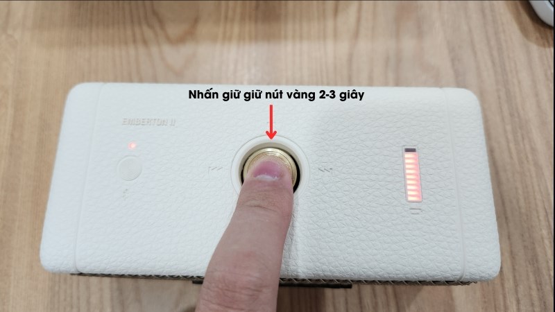 Nhấn giữ nút vàng nằm giữ phần trên loa Marshall Emberton II trong 2-3 giây 