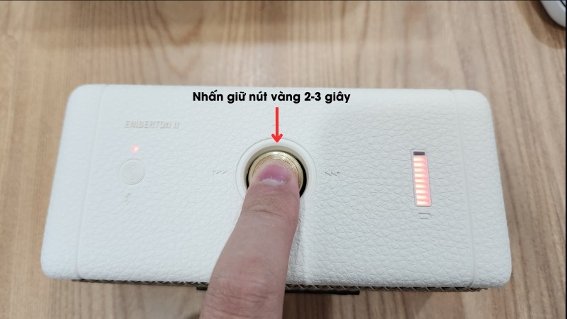 Nhấn giữ nút vàng nằm giữ phần trên loa Marshall Emberton II trong 2-3 giây 